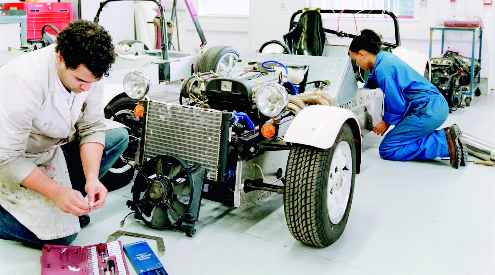 Two engineering students work on a car at Kingston ISC