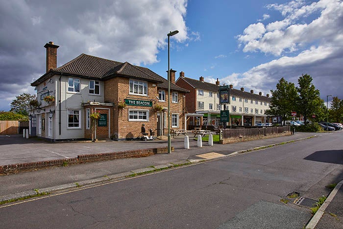 A pub next to some shops with flats above them. 