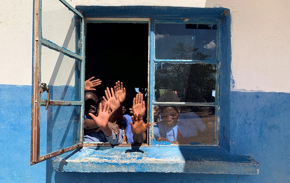 Students waving through a window.