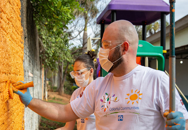 Volunteers Painting a wall orange in Sumare Brazil 