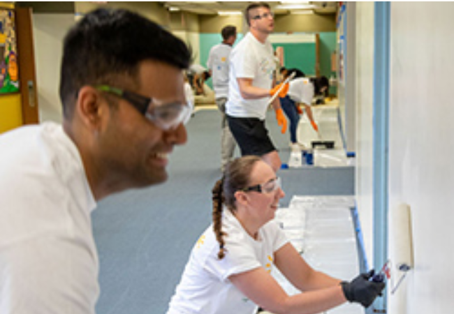 volunteers painting wall white 