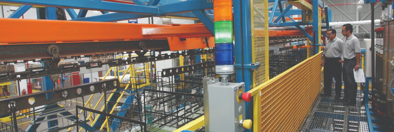 Overview of a vibrant factory floor featuring heavy machinery with conveyor belts, safety railings, and various equipment, highlighting the complexity and scale of an industrial operation