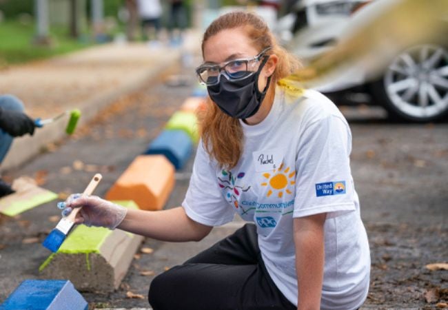 woman painting parking blocks