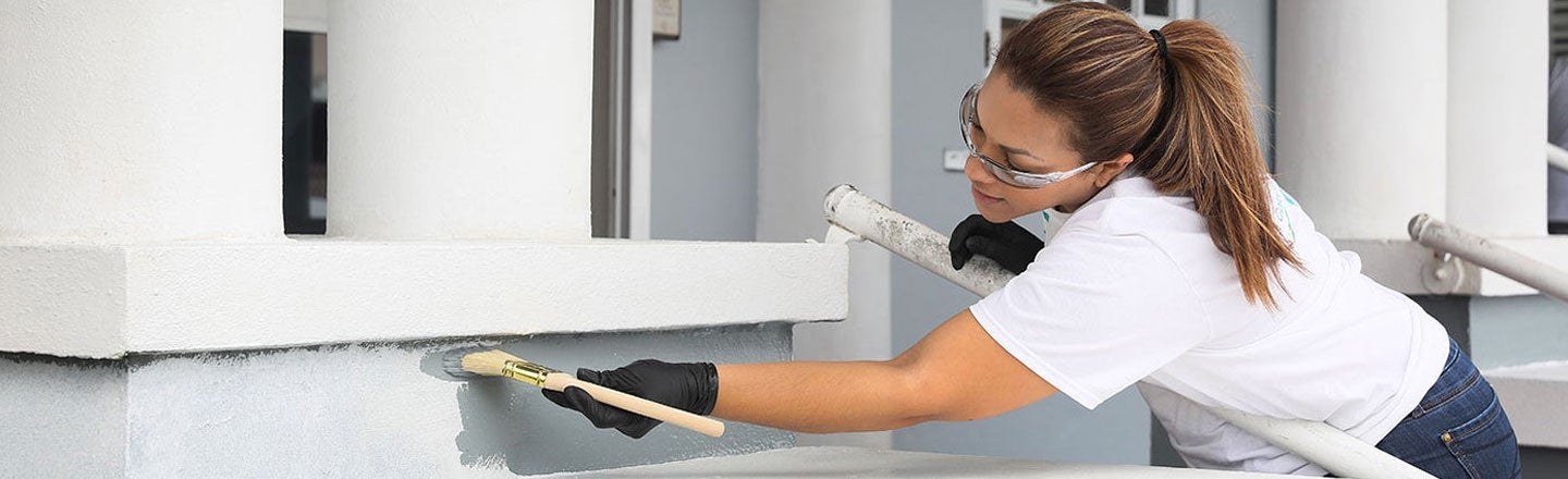 girl painting wall grey 