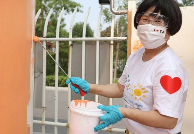 woman painting exterior wall