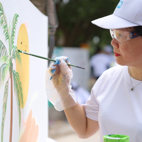 woman painting beach mural 