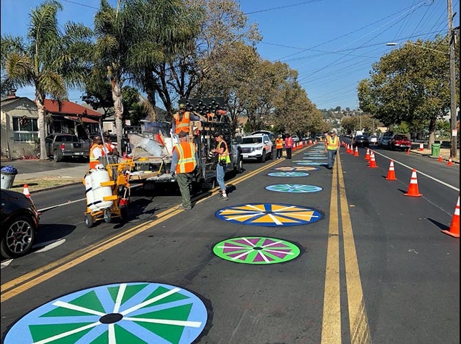 Workers applying markings to create a bike lane in Oakland, CA