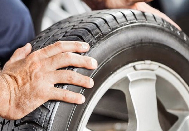 mans hand on car tire 