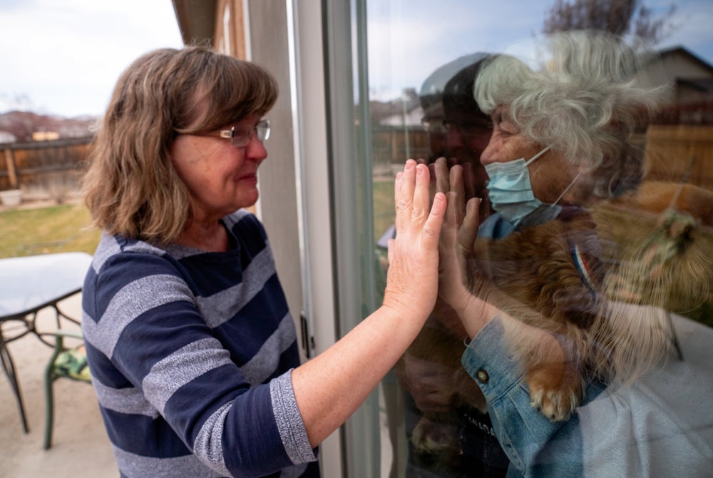 families separated by glass because of covid 19 