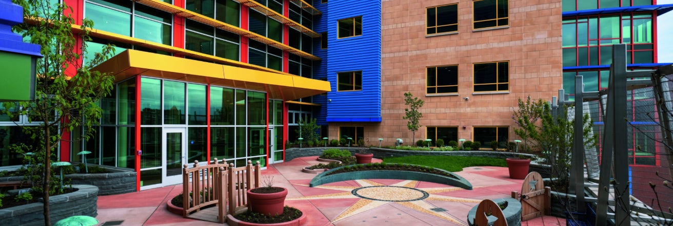 Brightly colored children's hospital including garden and play area.