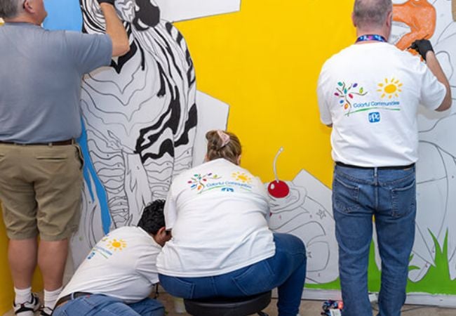 volunteers painting colorful mural in Orlando Florida 