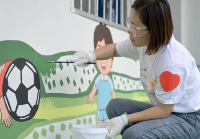 volunteer painting soccer mural in Guizhou, China 