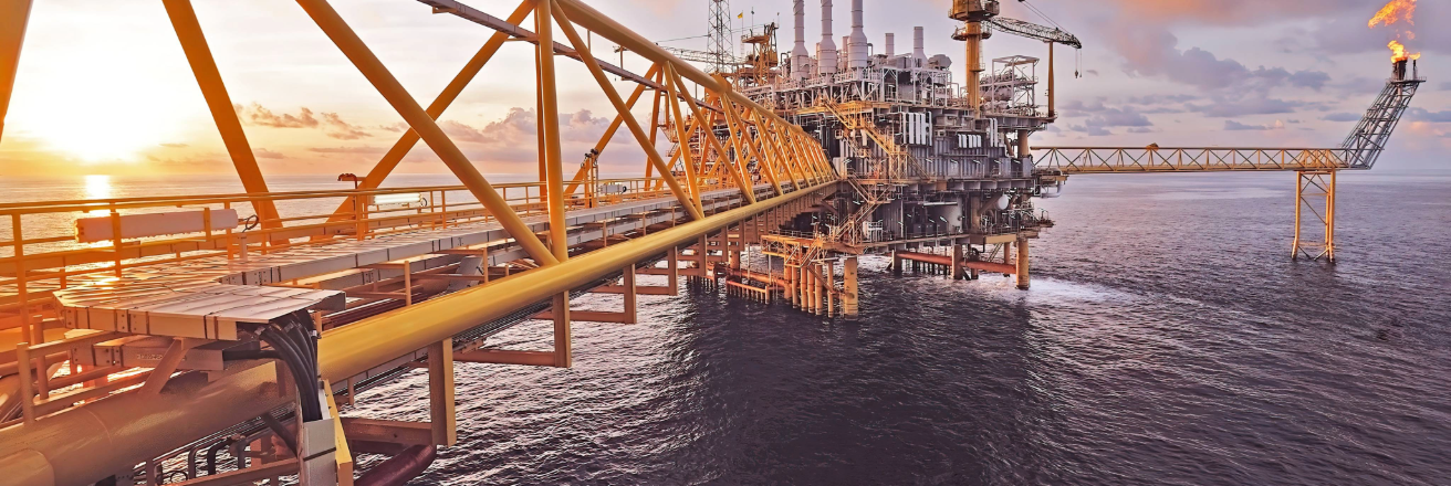 Offshore oil rig on a calm sea with a sunset in the background