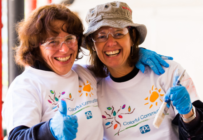 two happy volunteers painting in Deurne, Belgium  