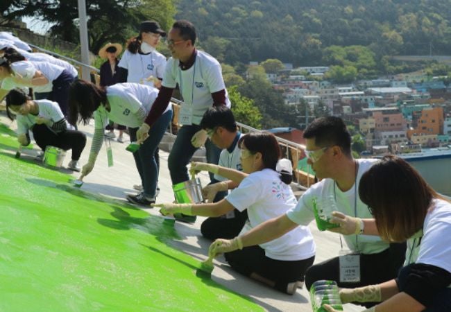 group of volunteer painters painting walkway green in South Korea 