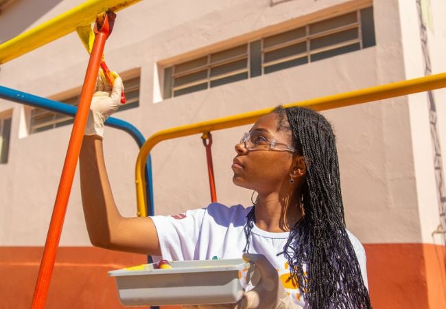 woman painting playground equipment