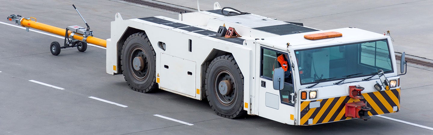 Large vehicle travelling along road with white coating