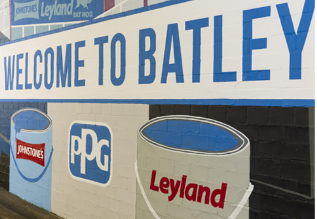 Wall mural of paint and PPG logo and a "welcome to Batley" call out 