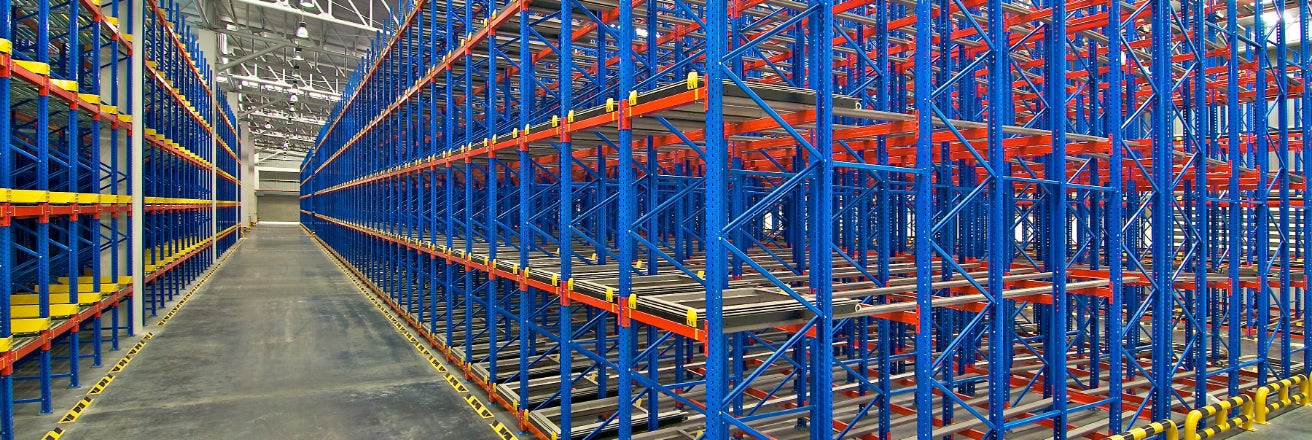 Red and blue shelving a racking structures in a large warehouse