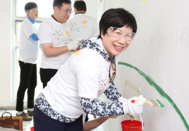 woman painting a green mural in Hong Kong 