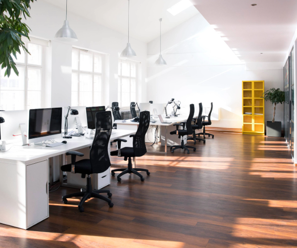 Empty office with white furniture, black desk chairs and yellow shelving