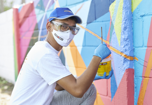 guy painting colorful wall mural 