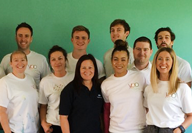 group of volunteers in front of green wall 