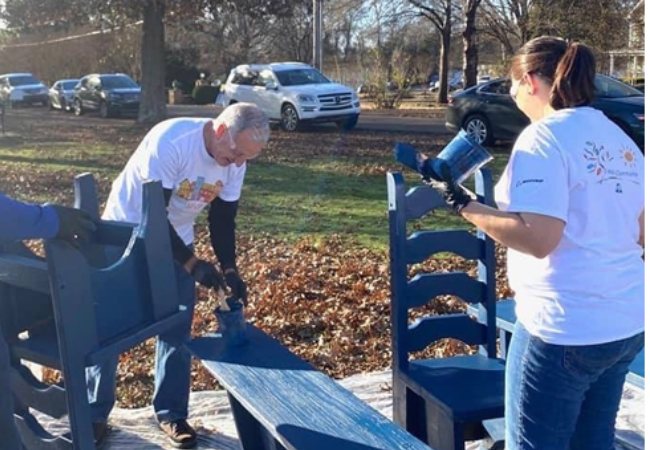 volunteers painting chairs blue.