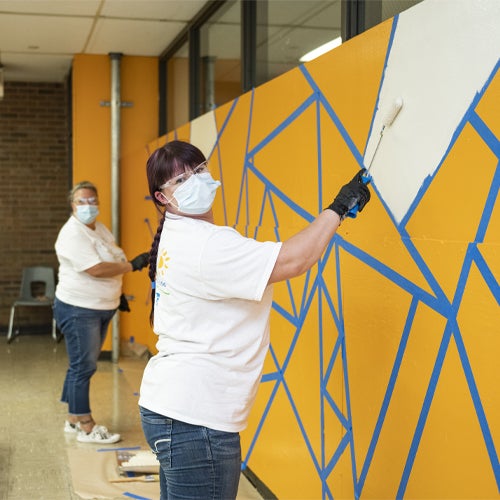 volunteers painting triangle mural 