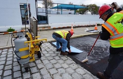 Workers applying colorful pedestrian walkway in Norwalk, CT