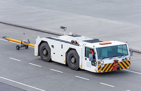 Large vehicle travelling along road with white coating