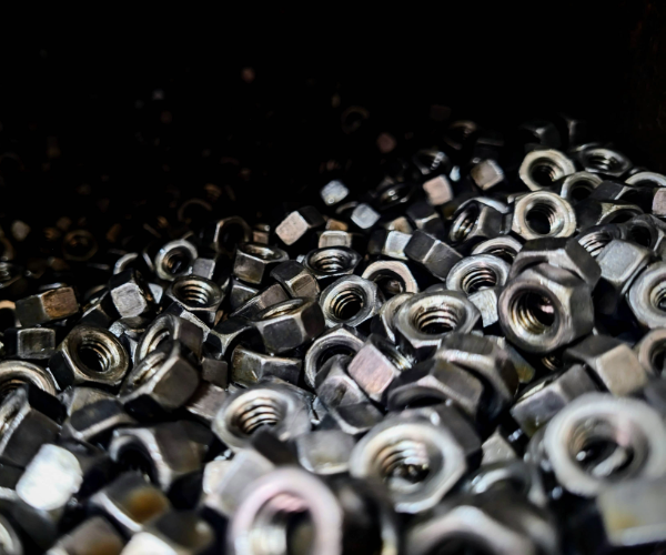 Close up view of a pile of silver nuts for fasteners