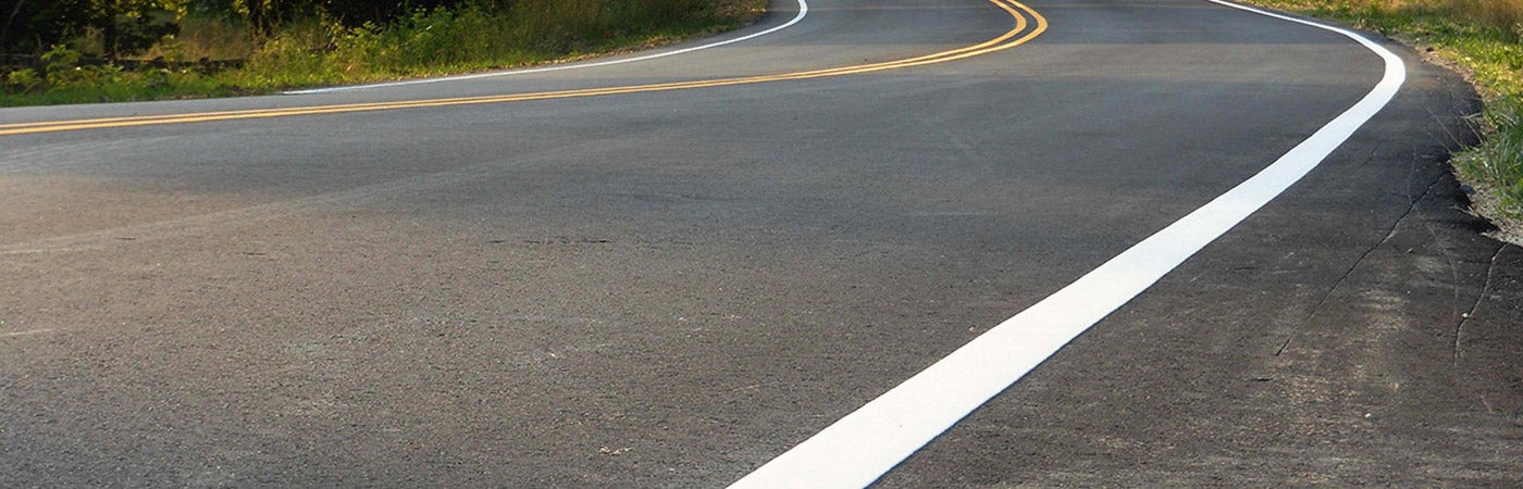 A curved country road with center and curb lines