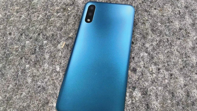 Gradient blue smartphone with dual cameras lying on a textured gray surface