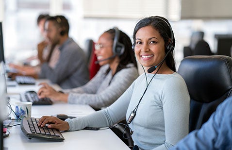 Female office worker using computer with headset