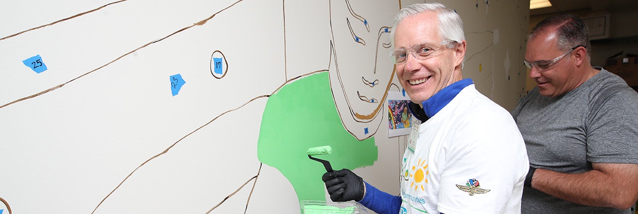 man painting mural on wall 