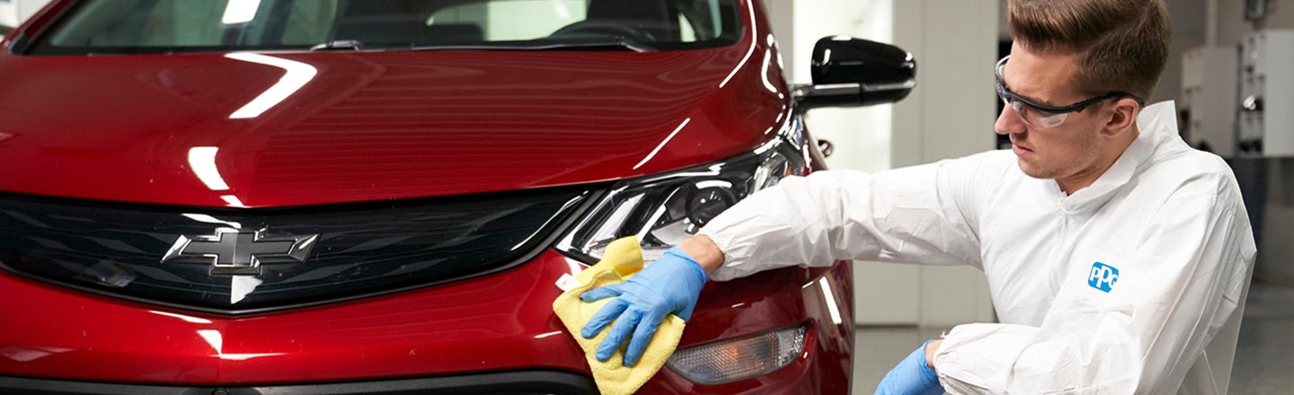 PPG worker polishing red car bodywork