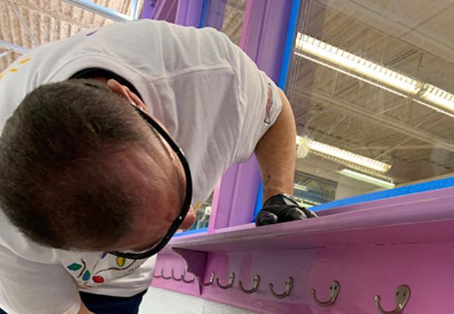 man painting hooks pink in Dallas, Texas 