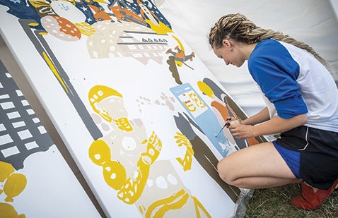 Volunteer painting mural as part of PPG Colorful Communities day