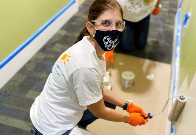 woman rolling paint on interior wall