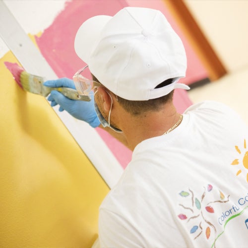 Volunteer in Alessandria Italy painting a mural 