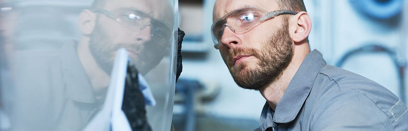 Male worker polishing vehicle panel