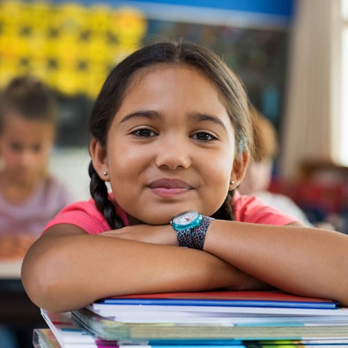 student smiling and leaning on school work 