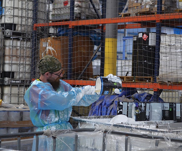 Worker examining can of PPG paint