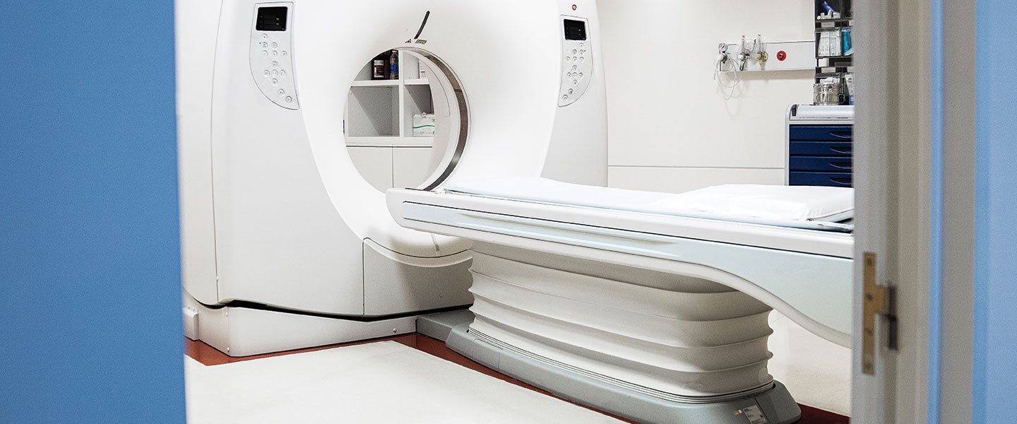 View through an open door to a modern MRI machine in a clean hospital room, highlighting the advanced medical imaging technology