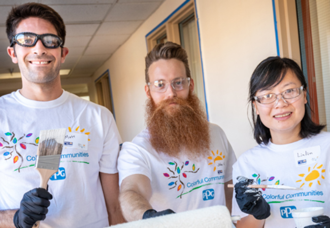 three volunteers ready to paint a wall white 