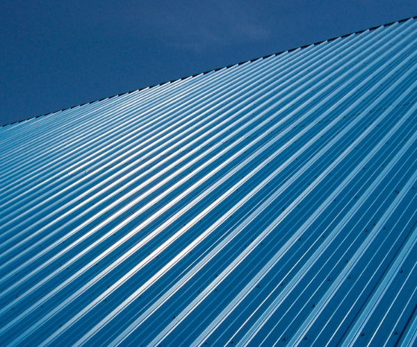 Vertical view of blue roofing panels against a blue sky