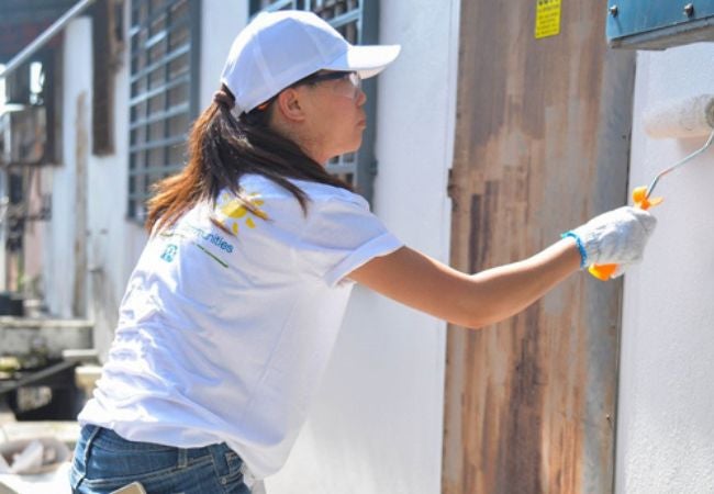 woman painting exterior wall