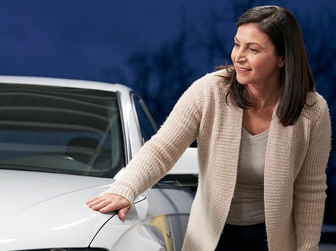 Woman inspecting car body work