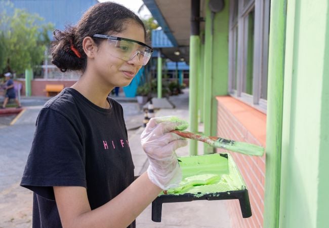 Volunteer in Brazil painting a school